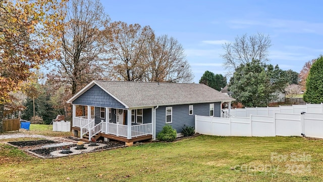 back of house with a lawn and covered porch