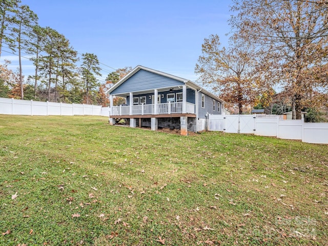 rear view of property with a lawn and a deck