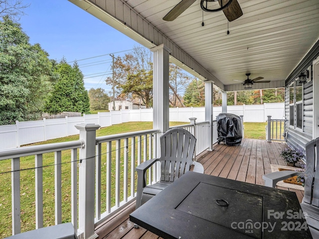 deck with a lawn and ceiling fan