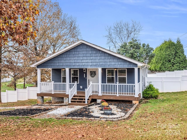 bungalow featuring a porch and a front lawn