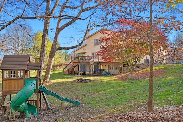 view of play area with a lawn, a trampoline, and a wooden deck