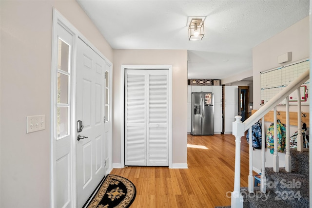 entrance foyer with a textured ceiling and light wood-type flooring