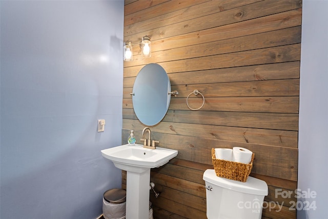 bathroom featuring toilet and wooden walls