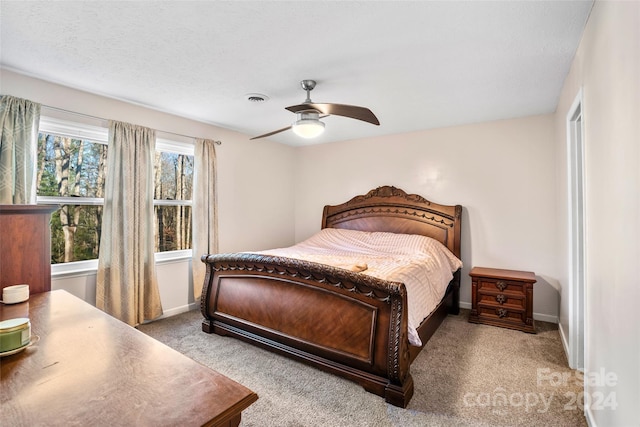 bedroom with carpet flooring, ceiling fan, and a textured ceiling