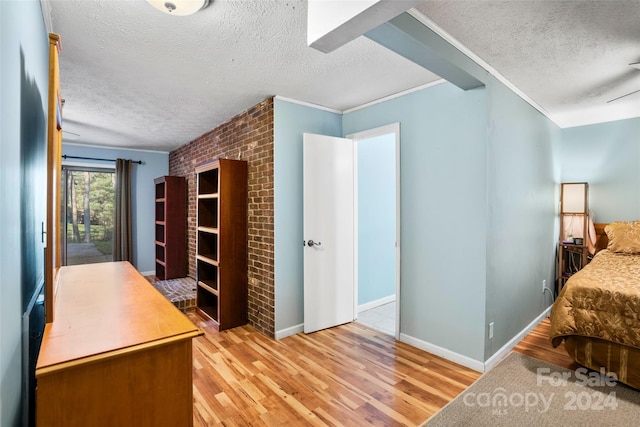 office area with light hardwood / wood-style floors, crown molding, and a textured ceiling