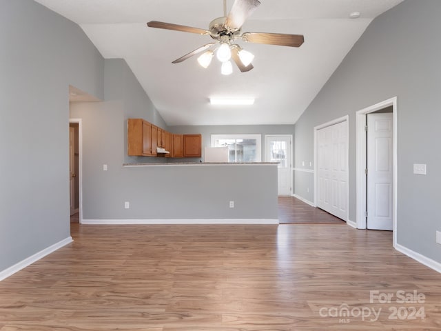 unfurnished living room with high vaulted ceiling, light hardwood / wood-style flooring, and ceiling fan