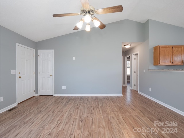 unfurnished living room featuring light hardwood / wood-style floors, vaulted ceiling, and ceiling fan