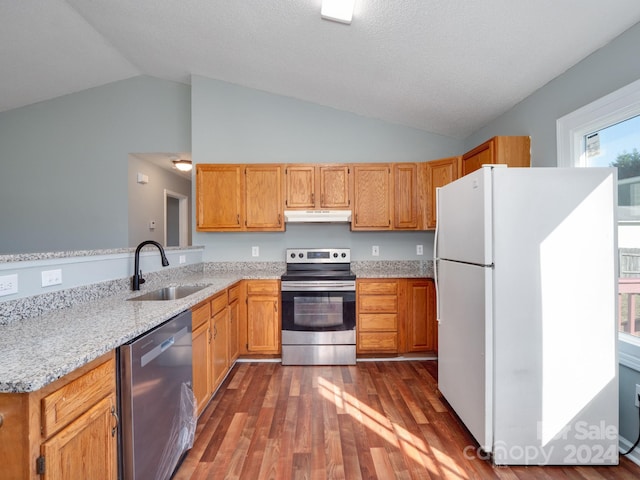 kitchen with light stone countertops, dark hardwood / wood-style flooring, stainless steel appliances, sink, and lofted ceiling