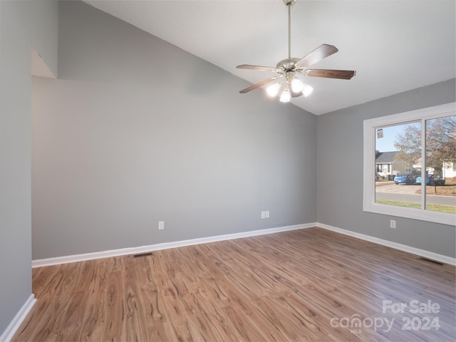 unfurnished room with hardwood / wood-style flooring, ceiling fan, and vaulted ceiling