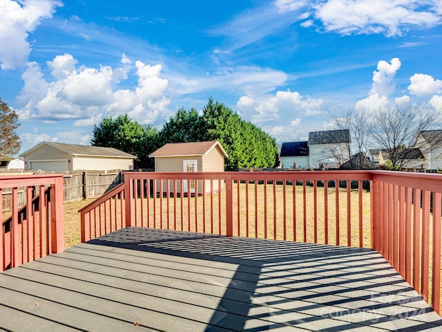 deck with a yard, a water view, and a storage shed