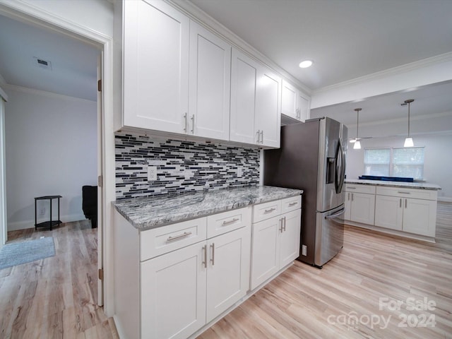 kitchen featuring white cabinets, decorative backsplash, light wood-type flooring, and crown molding