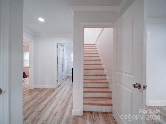 stairs with hardwood / wood-style flooring and crown molding