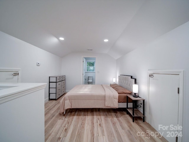 bedroom with light wood-type flooring and vaulted ceiling