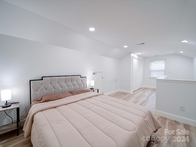 bedroom featuring light hardwood / wood-style flooring and vaulted ceiling