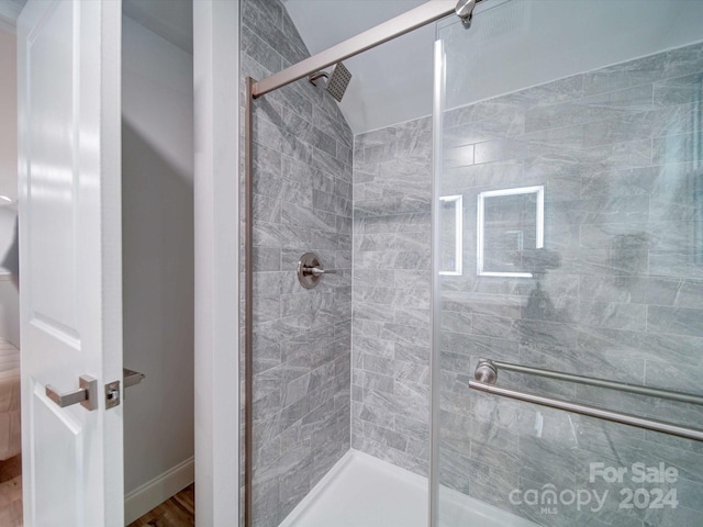 bathroom featuring hardwood / wood-style flooring and a shower with shower door