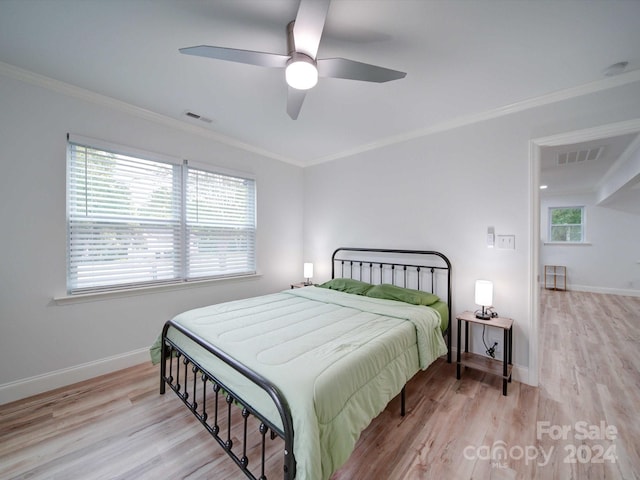 bedroom with ceiling fan, crown molding, and light wood-type flooring