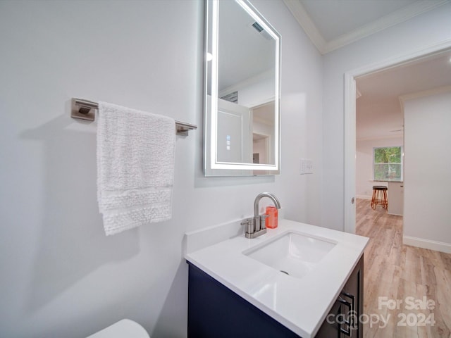 bathroom featuring hardwood / wood-style floors, vanity, and ornamental molding