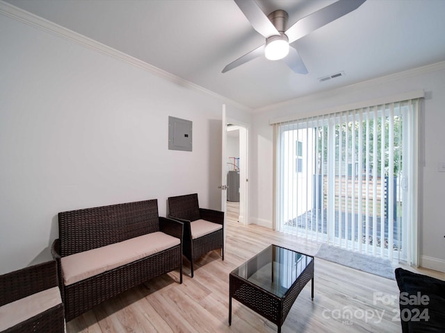 living area with electric panel, light hardwood / wood-style flooring, ceiling fan, and crown molding