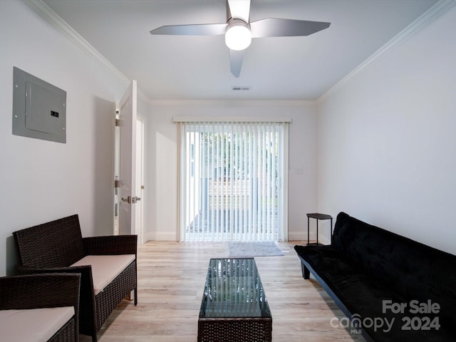 living room featuring electric panel, ceiling fan, crown molding, and light wood-type flooring