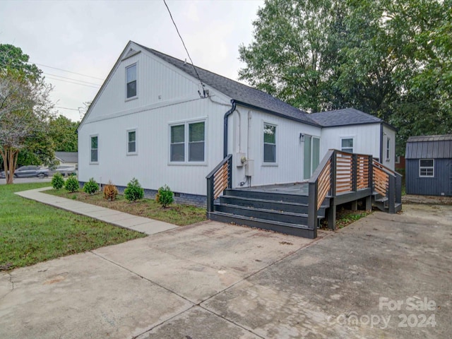 view of front of home with a storage shed and a wooden deck