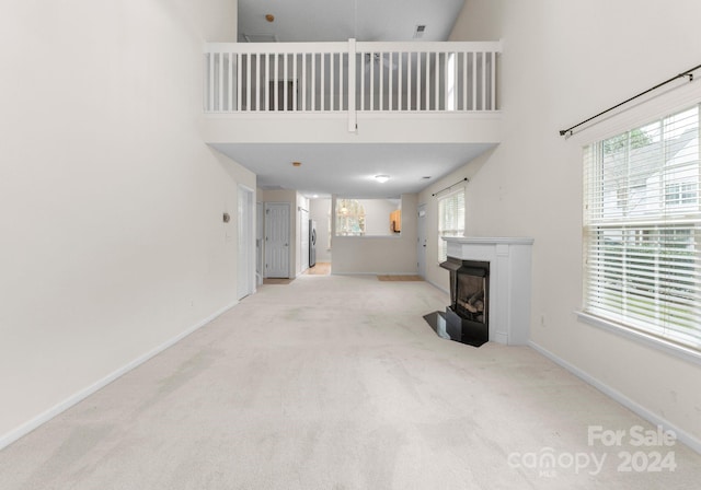 living room with light colored carpet and a towering ceiling