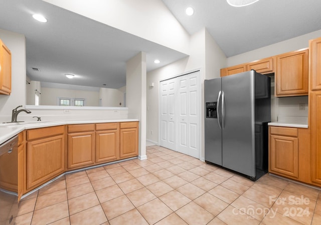 kitchen featuring sink, light tile patterned floors, stainless steel appliances, and vaulted ceiling