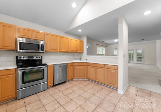 kitchen featuring lofted ceiling, light tile patterned floors, and appliances with stainless steel finishes