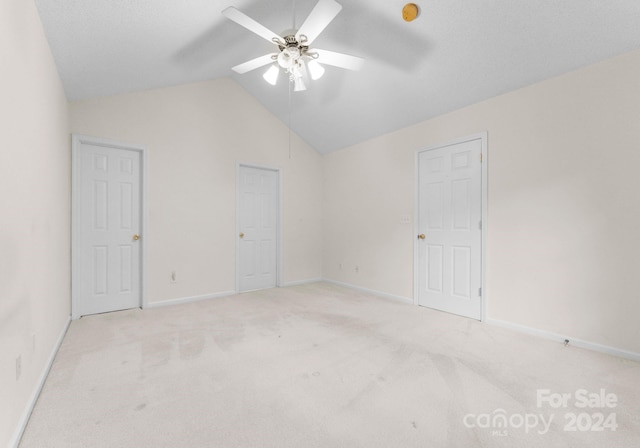 carpeted empty room featuring ceiling fan and lofted ceiling