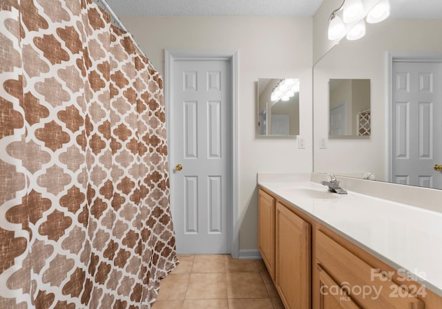 bathroom featuring a textured ceiling, vanity, and tile patterned floors