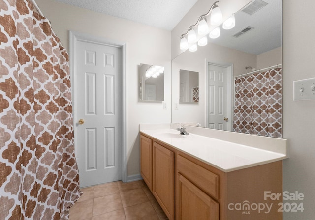 bathroom featuring tile patterned flooring, vanity, and a textured ceiling