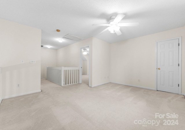 spare room featuring light carpet and ceiling fan