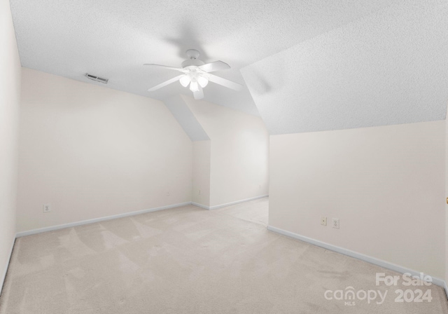 bonus room featuring light carpet, a textured ceiling, ceiling fan, and lofted ceiling