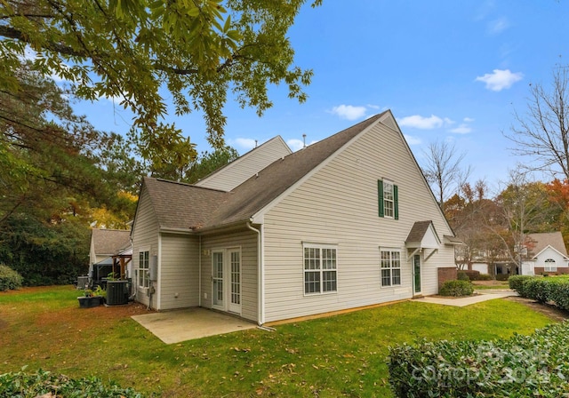 back of property featuring a lawn, a patio area, central air condition unit, and french doors