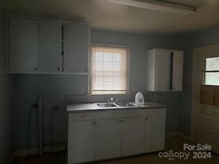 kitchen featuring white cabinets and sink