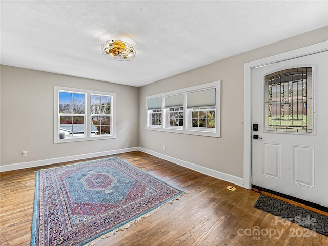 entrance foyer with hardwood / wood-style floors and a textured ceiling