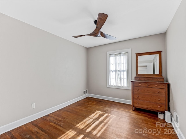 unfurnished bedroom featuring ceiling fan and dark wood-type flooring