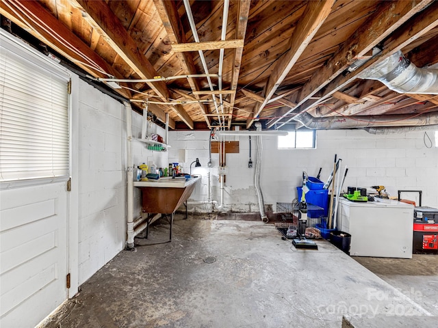 basement featuring white refrigerator and washer / clothes dryer