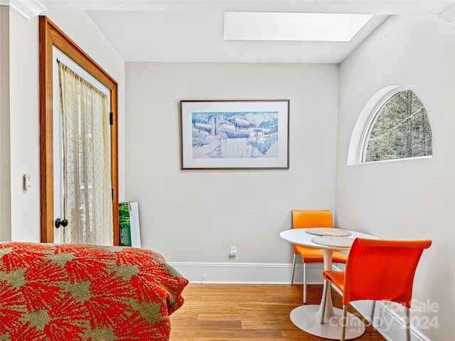 sitting room with hardwood / wood-style floors and a skylight