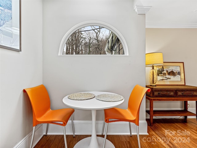 dining space with wood-type flooring and ornamental molding