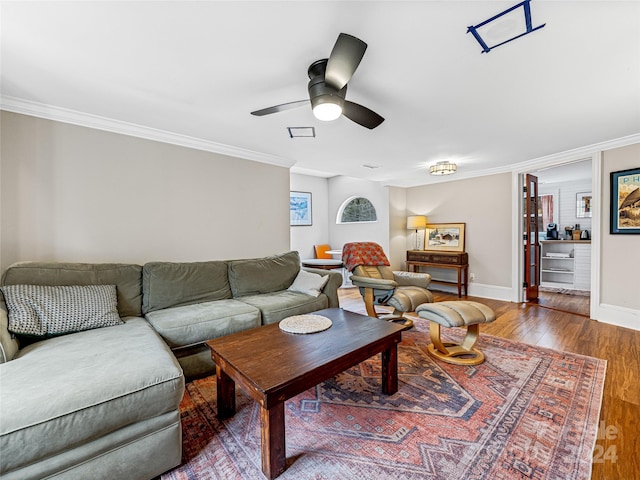 living room with hardwood / wood-style floors, ceiling fan, and crown molding