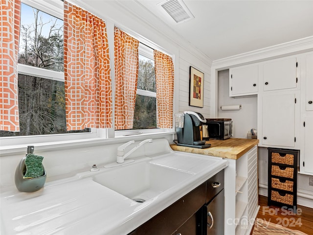 laundry room with light hardwood / wood-style floors, ornamental molding, and sink