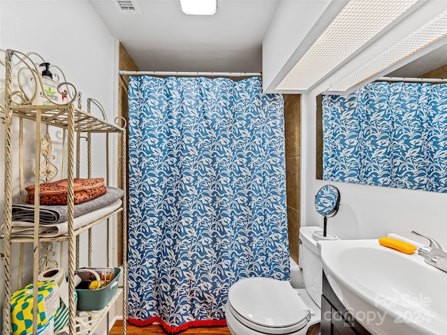 bathroom featuring a shower with curtain, toilet, and sink