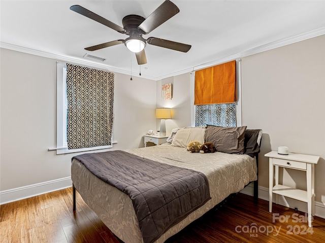 bedroom with ceiling fan, ornamental molding, and dark wood-type flooring