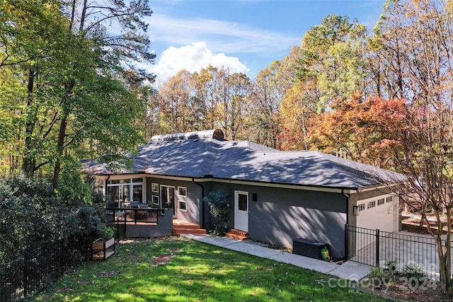 single story home with a garage, a front lawn, and a deck