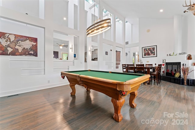 rec room featuring a tiled fireplace, dark hardwood / wood-style flooring, a high ceiling, and pool table