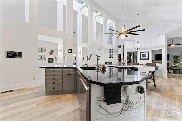 kitchen featuring gray cabinetry, sink, high vaulted ceiling, and light hardwood / wood-style flooring