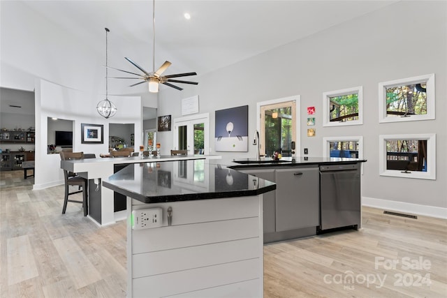 kitchen with dishwasher, high vaulted ceiling, a spacious island, sink, and light hardwood / wood-style flooring