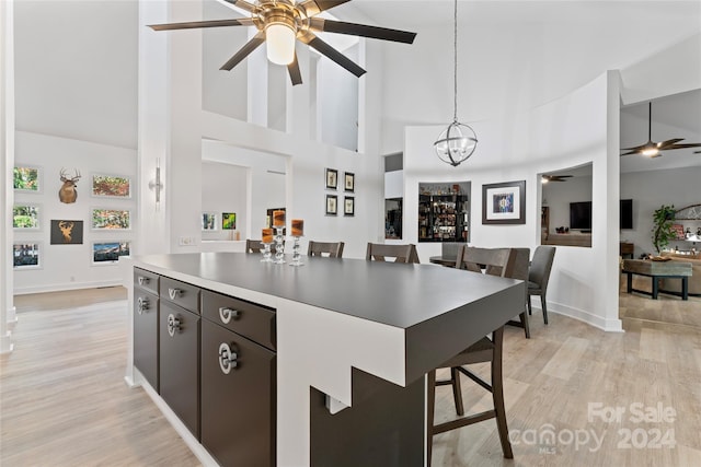 kitchen with decorative light fixtures, a kitchen breakfast bar, and a high ceiling