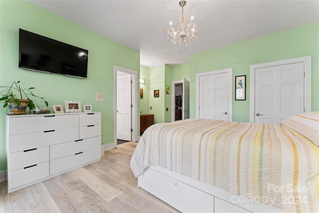 bedroom with light hardwood / wood-style floors, a notable chandelier, and ensuite bathroom