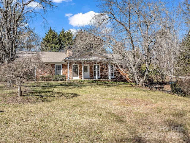 view of front of property with brick siding and a front lawn